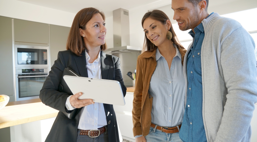 Couple with real-estate agent visiting house for sale